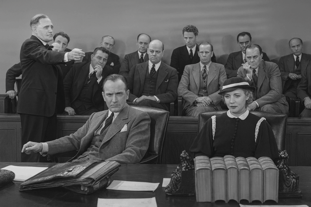 People in the courtroom Jury and 2 people at table and lawyer pointing at them